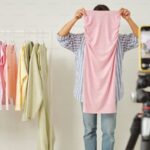 Woman packing trendy clothes into a box to sell online for cash, representing the best places to sell clothes online for money.