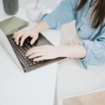 Laptop on desk with job list and coffee mug – symbolizing no-interview remote jobs that pay weekly