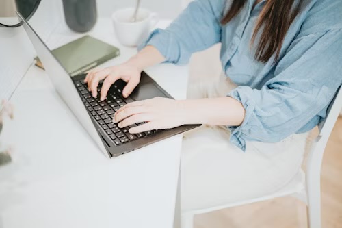 Laptop on desk with job list and coffee mug – symbolizing no-interview remote jobs that pay weekly